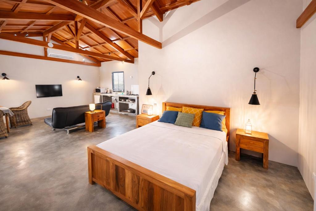 a bedroom with a large bed and a living room at Coconut Lodge Open-Plan Suite with Kitchen, Indoor & Outdoor Showers & Infinity Pool in Cap Malheureux