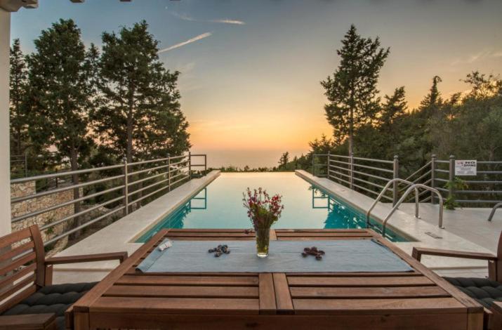 a table with flowers in a vase on top of a pool at Villa Alexa in Gaios