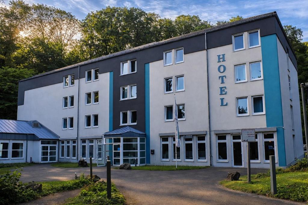 a large white and blue building with trees in the background at Koblenz Valley Hotel by Belvilla in Bendorf