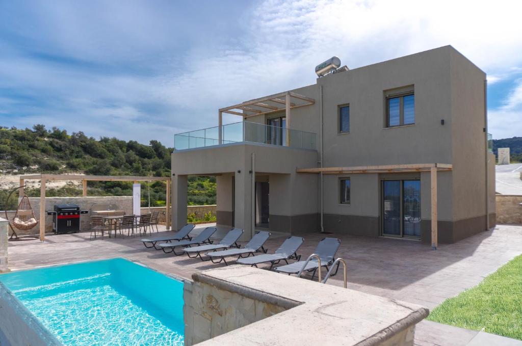 a villa with a swimming pool and a house at Amnia Villas with Private Pool in Kapsalianá