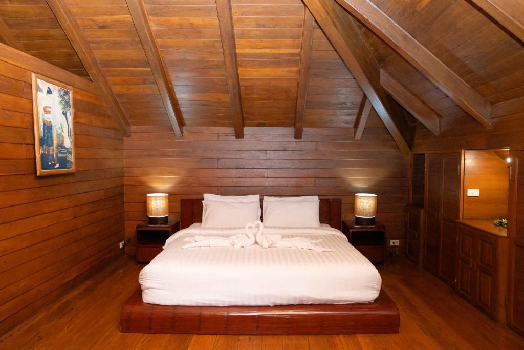 a bedroom with a white bed with two lamps at Stay At Lantana Mae Rim in Ban Pa Muang