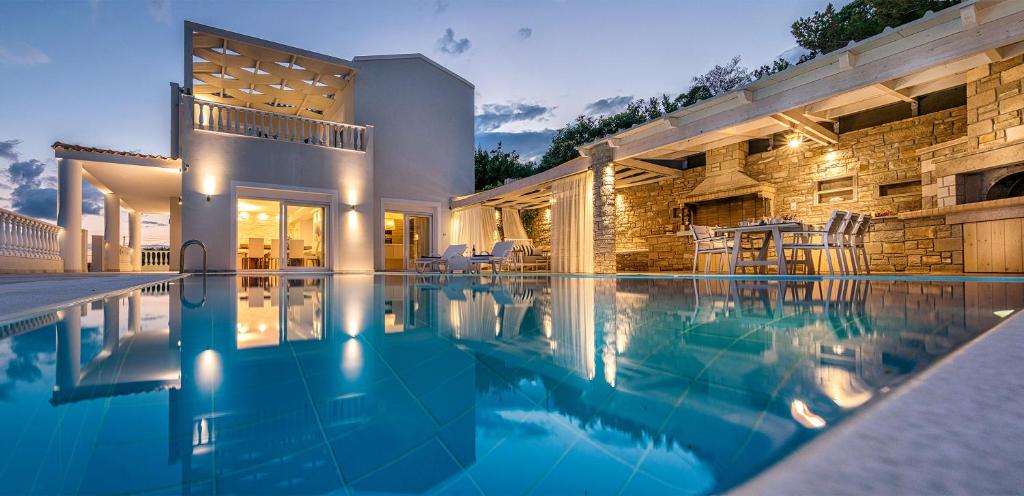 a swimming pool in front of a house at Villa Ariadne in Achlia