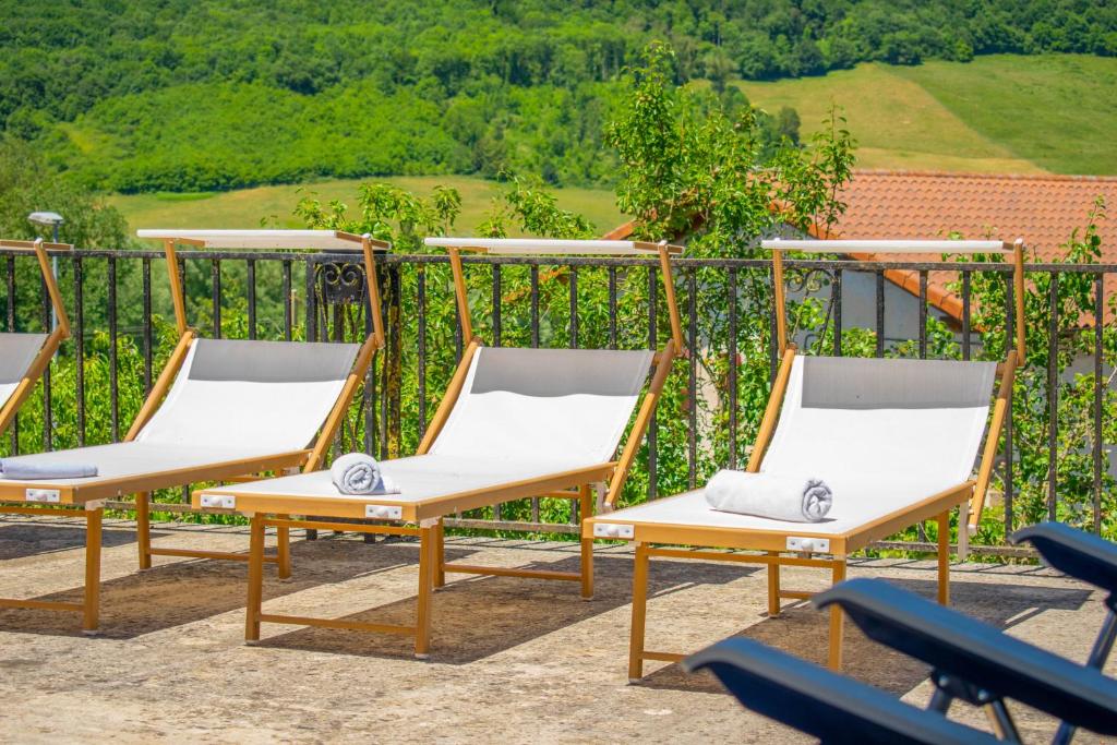 a group of chairs sitting on top of a balcony at Casa Arozenia, Hogar rústico en pleno valle Ulzama in Lizaso