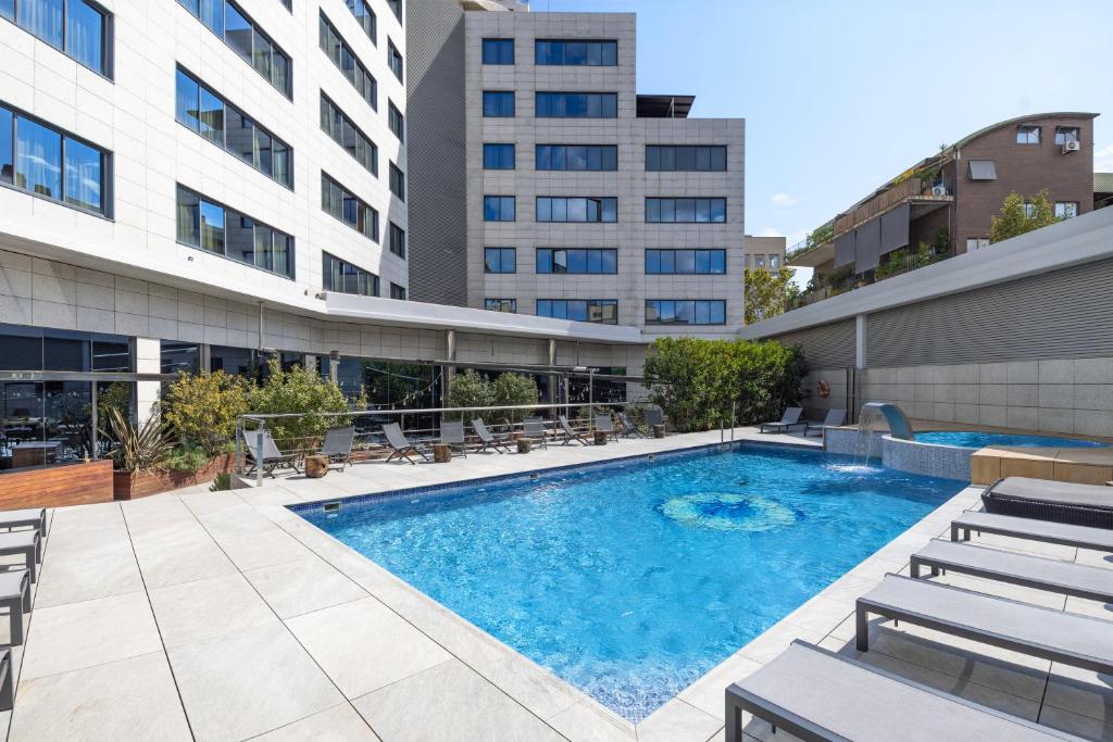 a swimming pool with chairs and a building at Hotel SB Icaria in Barcelona