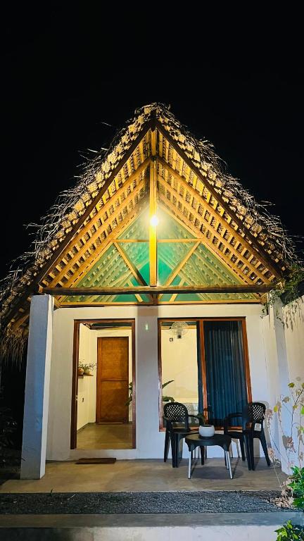 a house with two chairs and a table in front of it at Villa Carlos Tangalle in Tangalle