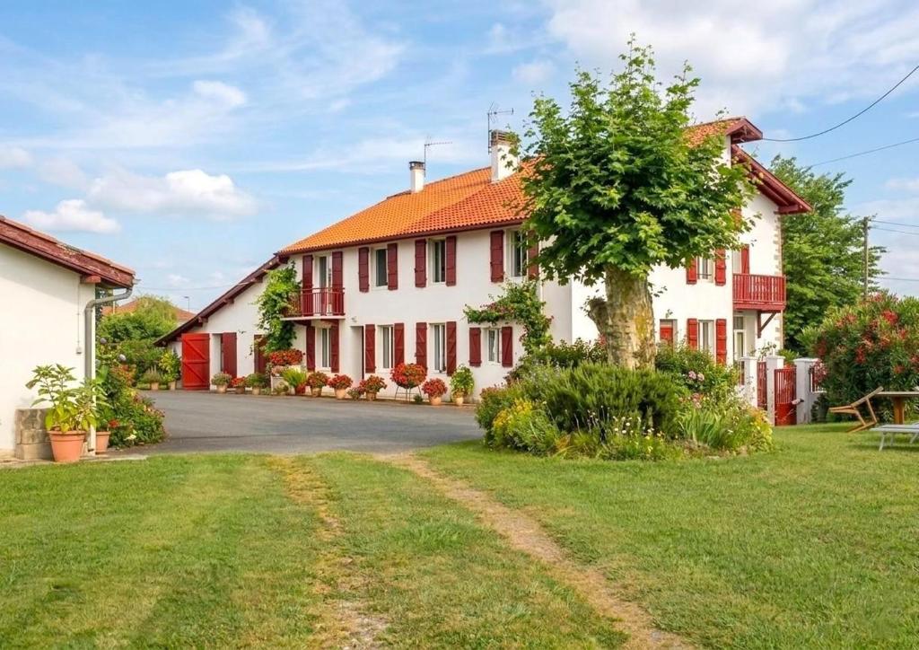 a large white house with red shutters at Anetania in Saint-Palais