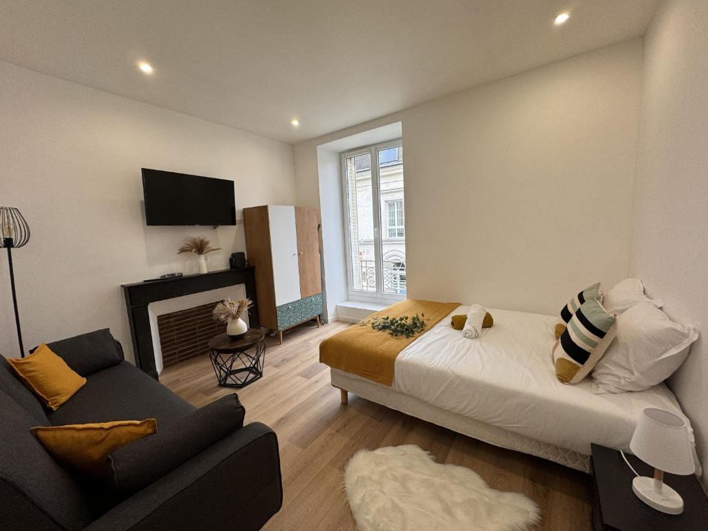 a bedroom with a bed and a couch and a fireplace at Le Cocon Maison Reve Excellence in Écommoy