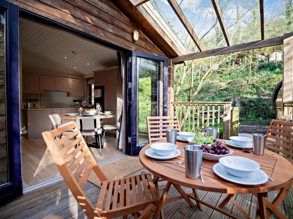 a wooden table and chairs on a wooden deck at 2 Bed in Truro oc-93315 in Porthtowan