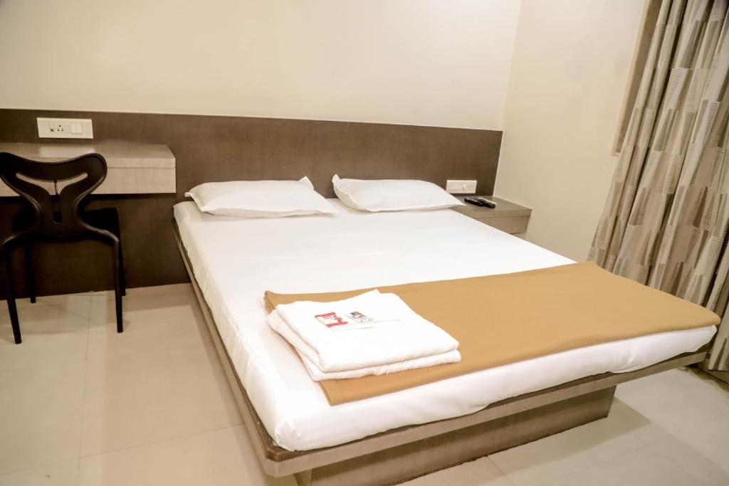 a bedroom with a bed with a towel on it at Hotel Maharaja in Thane