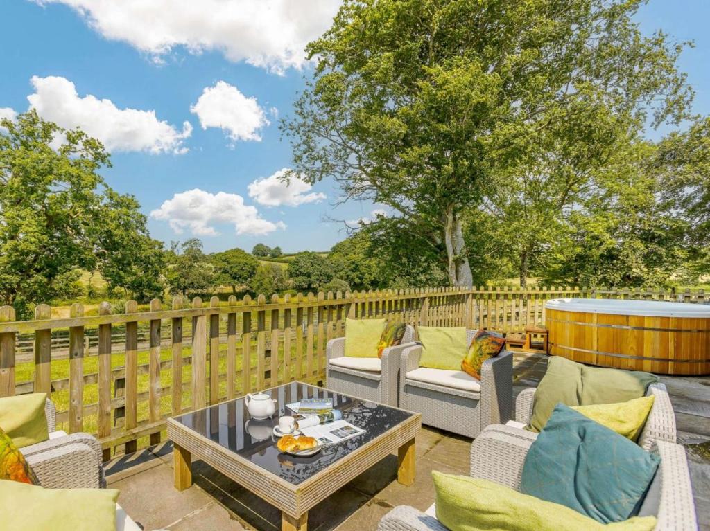 a patio with couches and a table on a fence at 3 Bed in Launceston oc-88858 in Saint Giles on the Heath