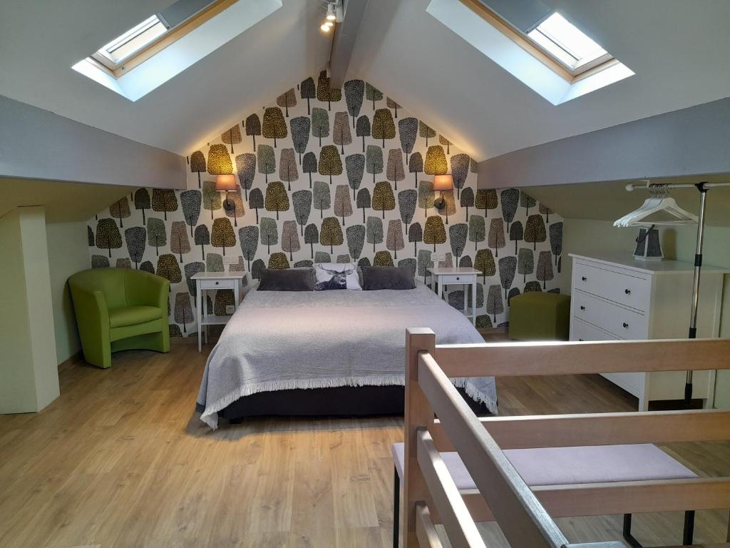 una camera da letto con un letto e due sedie verdi di Le Cerf volant a Libin