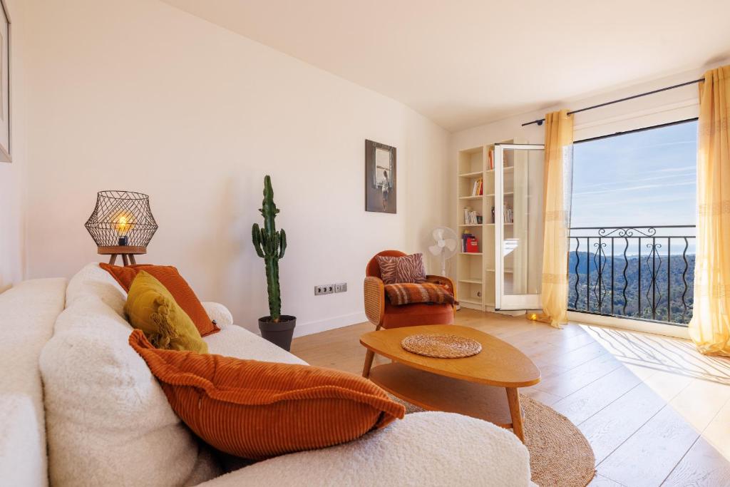 a living room with a couch and a table at Apt le Nid in Tourrettes-sur-Loup
