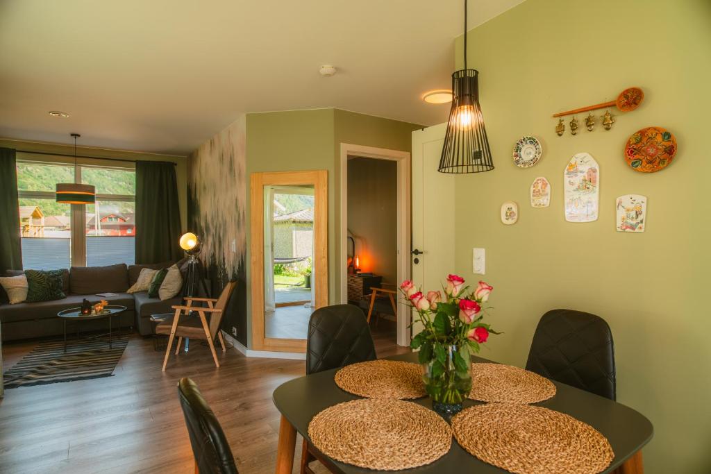 a living room with a table with a vase of flowers at Frafjord Apartments Frøya in Dirdal