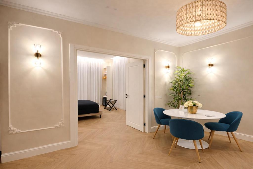 a living room with a table and chairs and a bed at SOFIA Suites & Rooms in Pompei