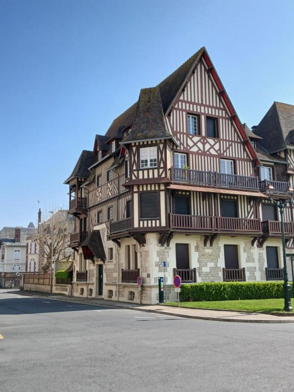 a large wooden building with a gambrel at Mer et Style au coeur de l'éventail 3 pièces 2 chambres in Cabourg