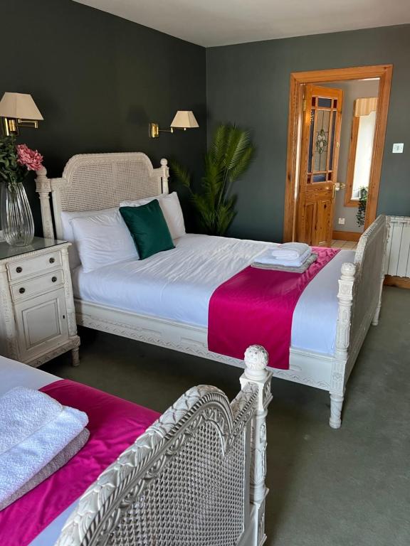 a bedroom with a white bed with a pink blanket at The Ormond Apartments in Dungarvan