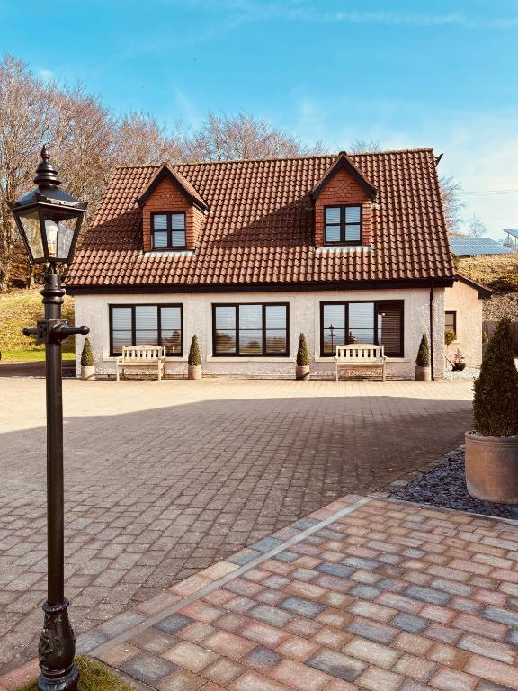 a house with a street light in front of it at The Cottage @ The Vu in Torphichen