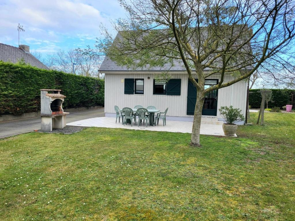 a backyard with a grill and a table and chairs at Maison De Bord De Mer in Pirou