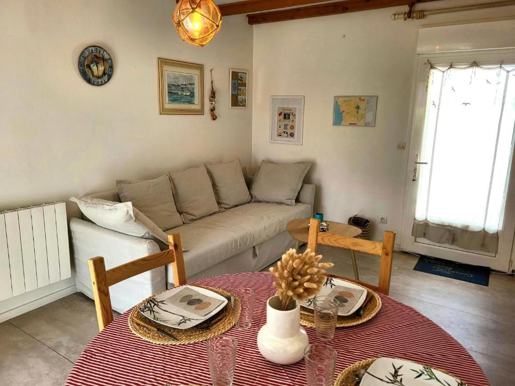 a living room with a couch and a table at Maison De Plage Le Cocon Pirouais in Pirou