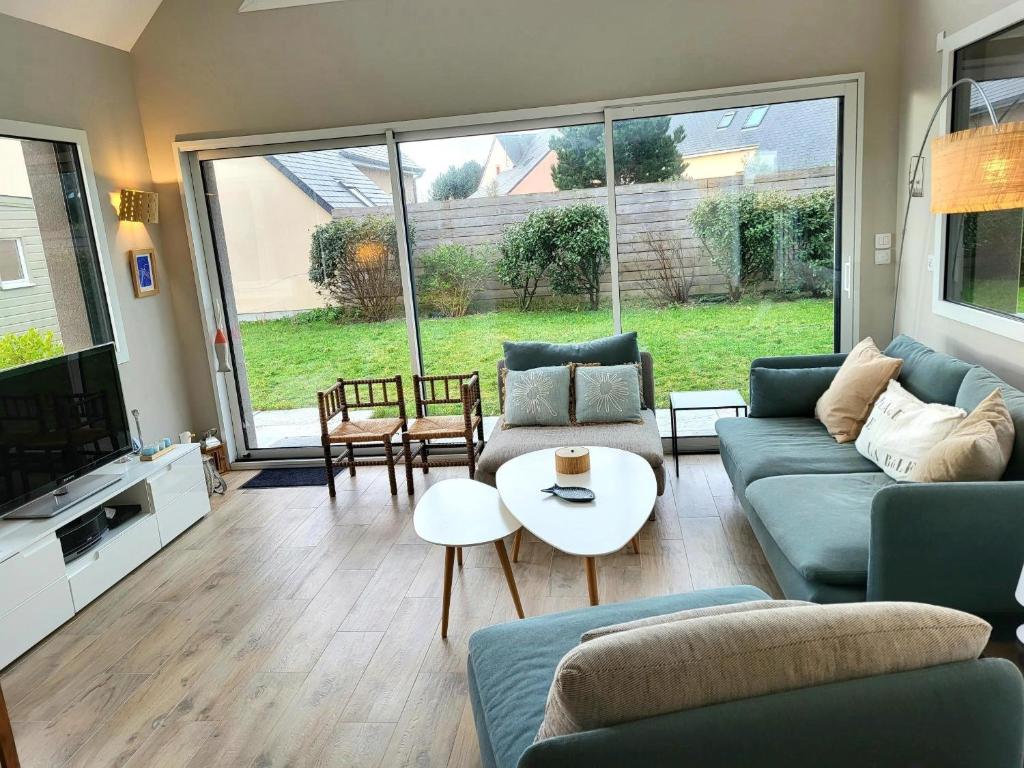 a living room with a couch and a table at Villa Des Havres in Saint-Germain-sur-Ay