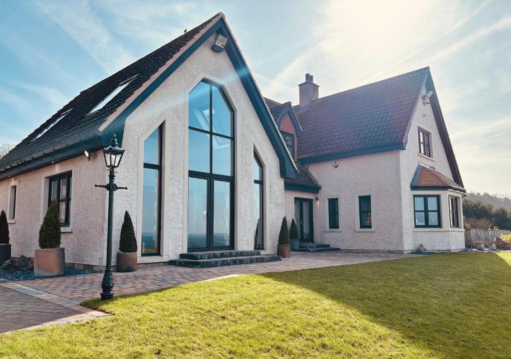a large white house with a black roof at The Hoose at The Vu in Bathgate