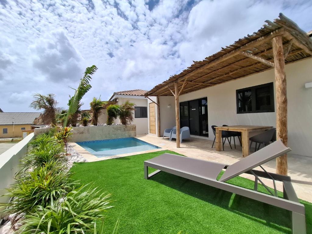 a backyard with a table and a lawn at Emma Luxury Pool Suites Resort in Willemstad