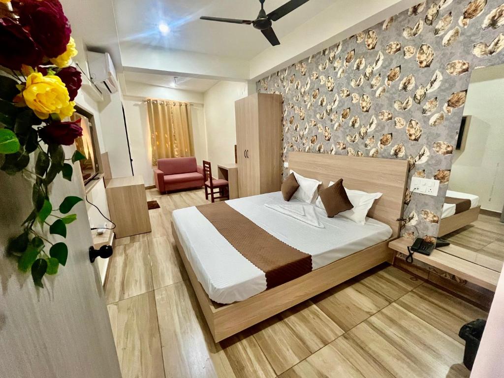 a bedroom with a bed with a wall with feathers at Deni Hotel in Patna