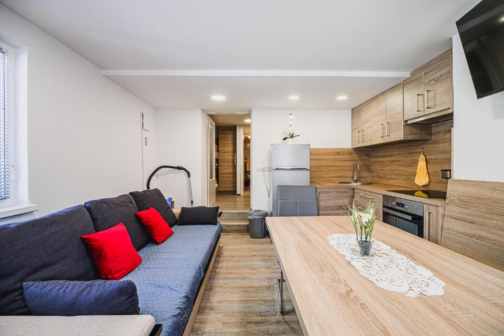a living room with a blue couch and a table at Apartment Kamrca na Kopah in Šmartno pri Slovenj Gradcu