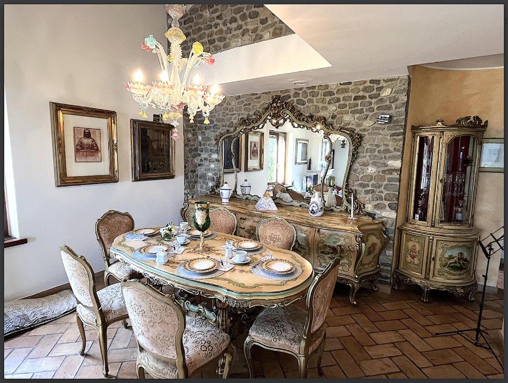 a dining room with a table and chairs and a mirror at B&B Art Experience Novecento e Dintorni in Monte Grimano Terme