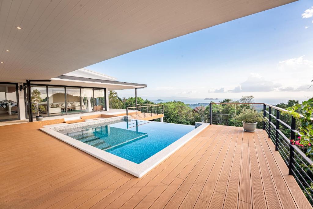 a house with a swimming pool on a deck at Titine Villa in Srithanu