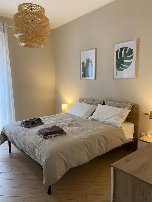 a bedroom with a large bed and a chandelier at A Casa di Katia in Collegno