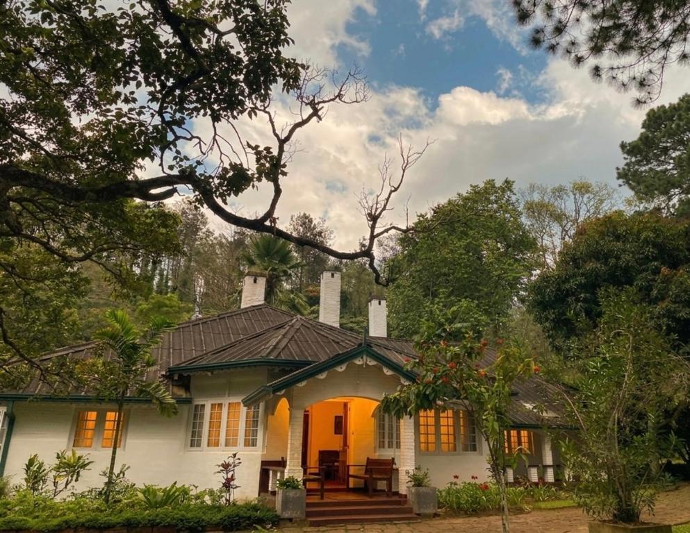 a white house with an orange door and trees at Malwatte Bungalows in Hali Ela