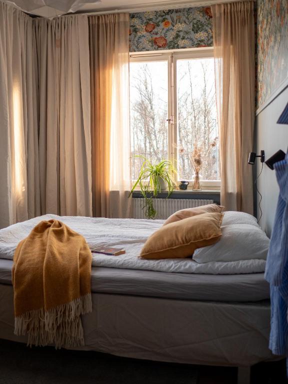 a bedroom with a bed with a window and a blanket at Marinans Guesthouse in Nävekvarn