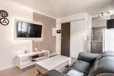 a living room with a couch and a tv at Charme et confort in Valenton