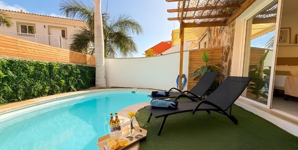 a patio with two chairs and a swimming pool at Palmview Private Pool in Arguineguín