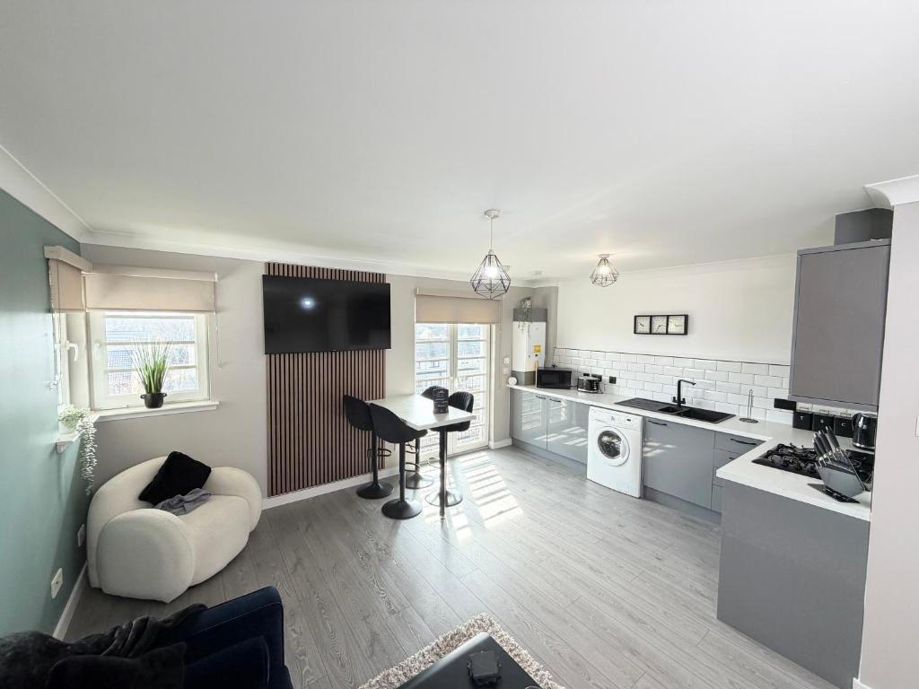 a kitchen and living room with a couch and a table at Bathgate Penthouse near Edinburgh in Bathgate