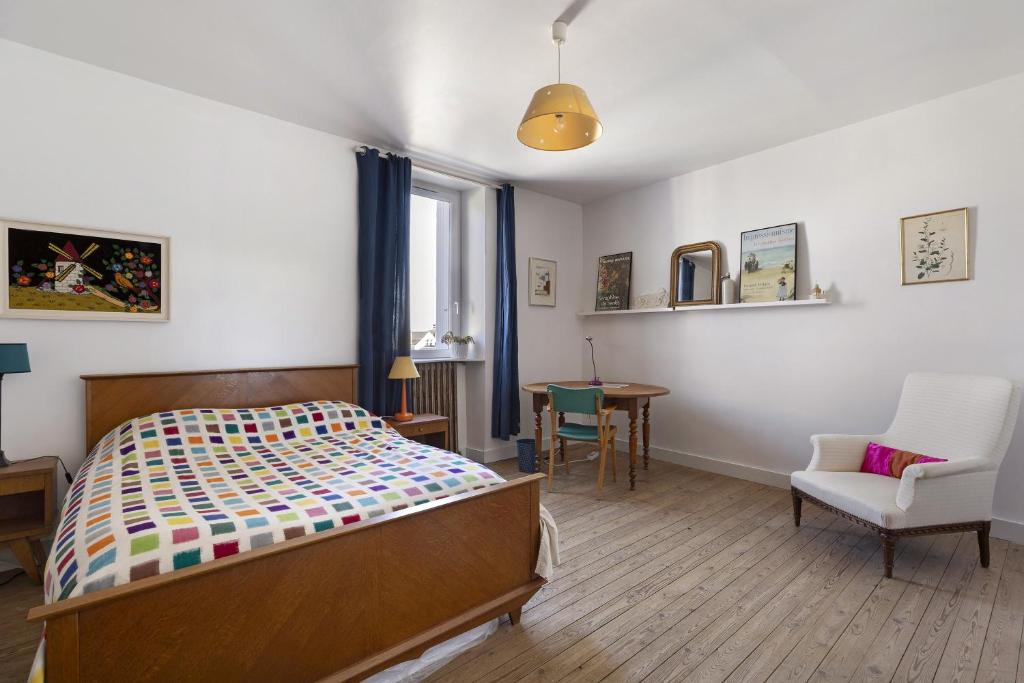 a bedroom with a bed and a chair and a table at Quartier De La Madeleine in Angers