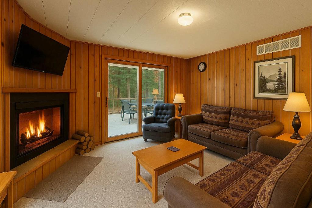 a living room with a couch and a fireplace at Pine & Paddle in Saint Germain