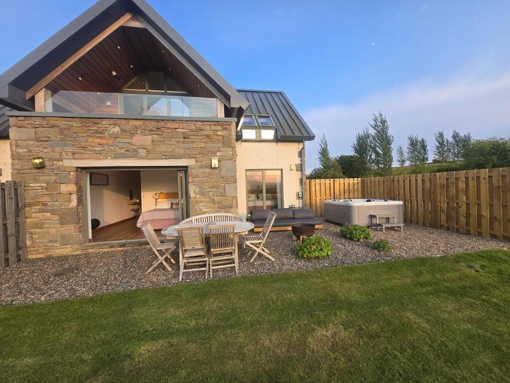 a patio with a table and chairs in a yard at 2 Bed in Forfar oc-92621 in Aberlemno