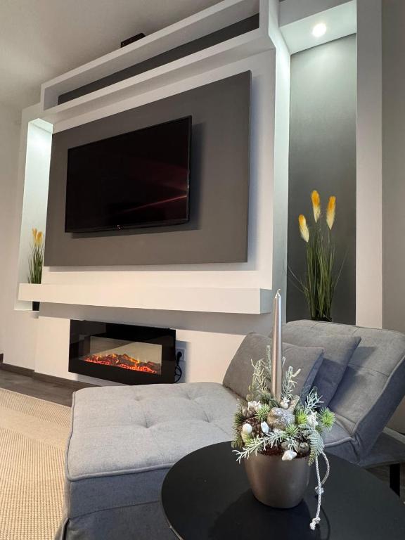 a living room with a couch and a fire place at Léda Vendégház in Vásárosnamény
