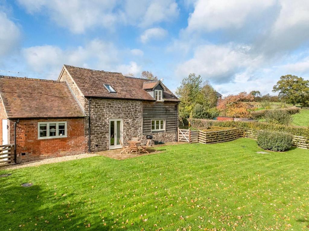 a brick house with a lawn in front of it at 2 Bed in Ludlow oc-83363 in Hopton Cangeford