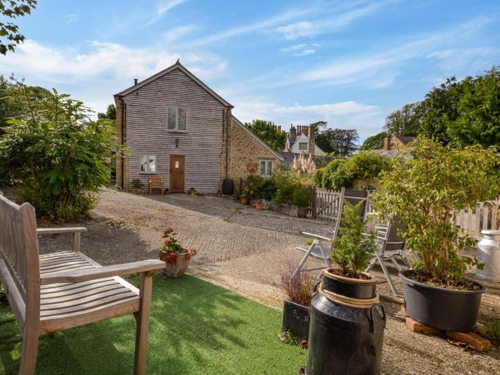 a garden with a bench and a house at 2 Bed in Bridport oc-dc081 in Loders