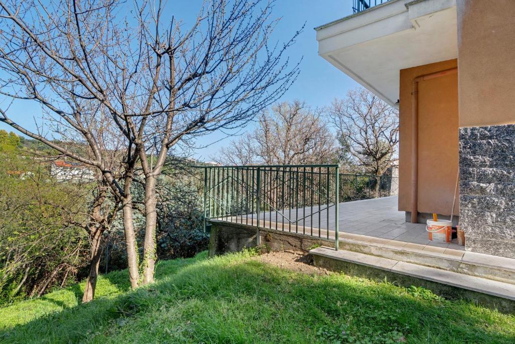 a porch of a house with a fence and a tree at Il Faro in Celle Ligure