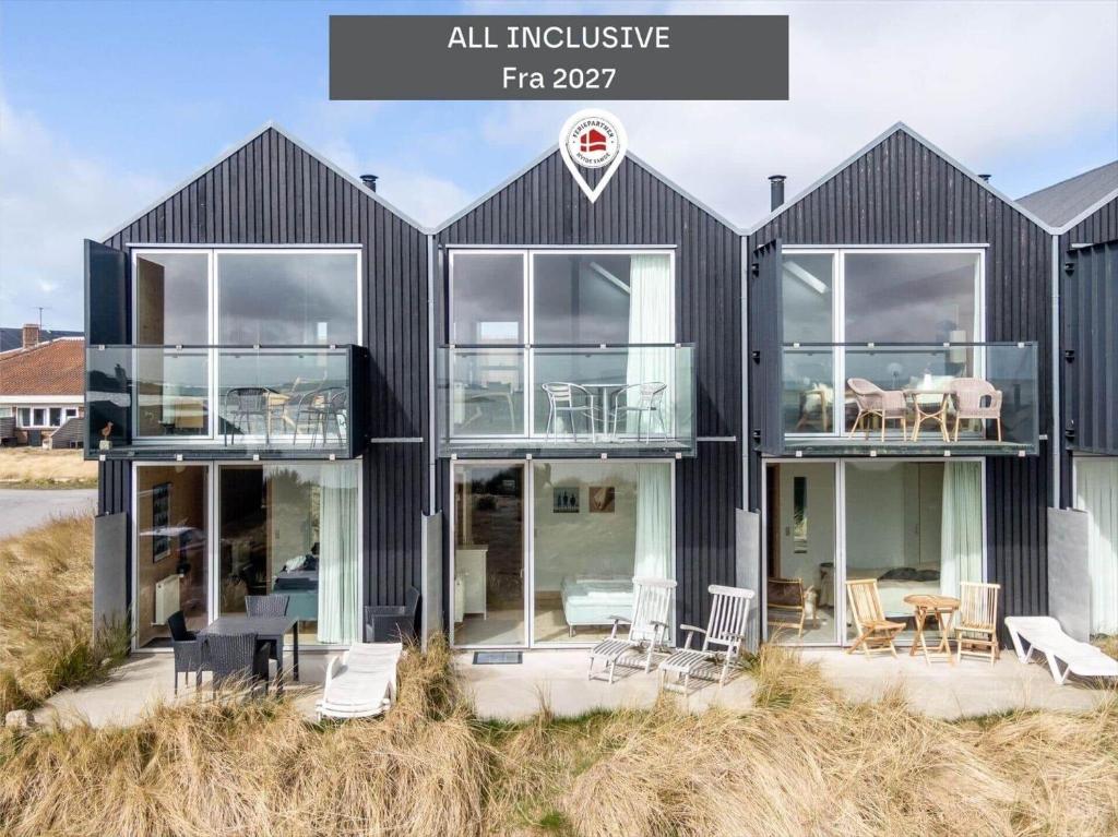 a black house with glass doors on a beach at 723-Hvide-Sande-Slusen-23 in Hvide Sande