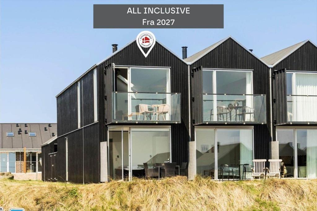 a black house with glass windows on top of a hill at 722-Hvide-Sande-Slusen-22 in Hvide Sande
