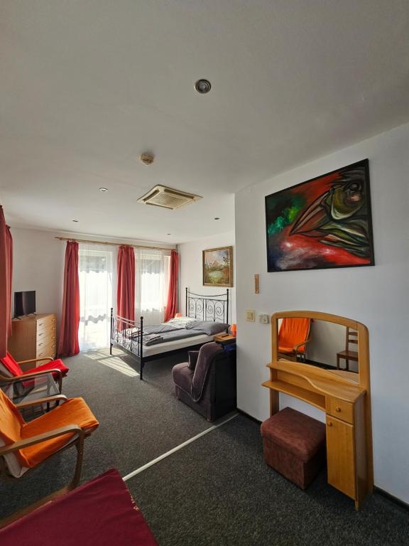 a living room with a bed and a desk at Pension Zlata Noha in Bratislava
