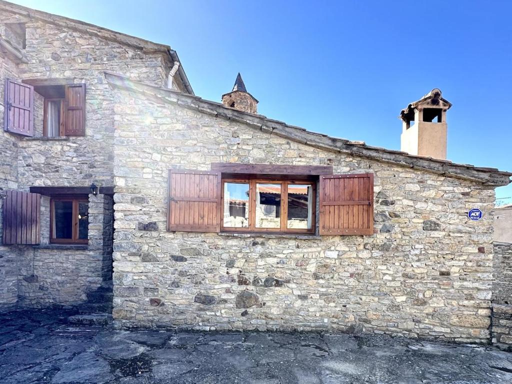 an old stone building with windows on it at Cal Grit casa de muntanya a Pont de Bar in Bar