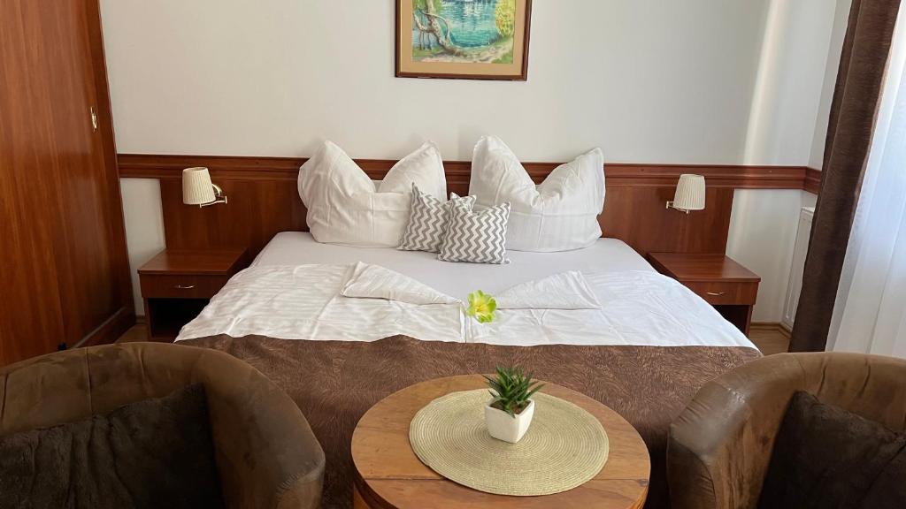 a hotel room with a bed with two chairs and a table at Kőnig apartman in Hévíz