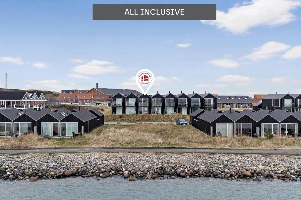 a group of houses on a hill next to the water at 7716-Hvide-Sande-Slusen-16 in Hvide Sande