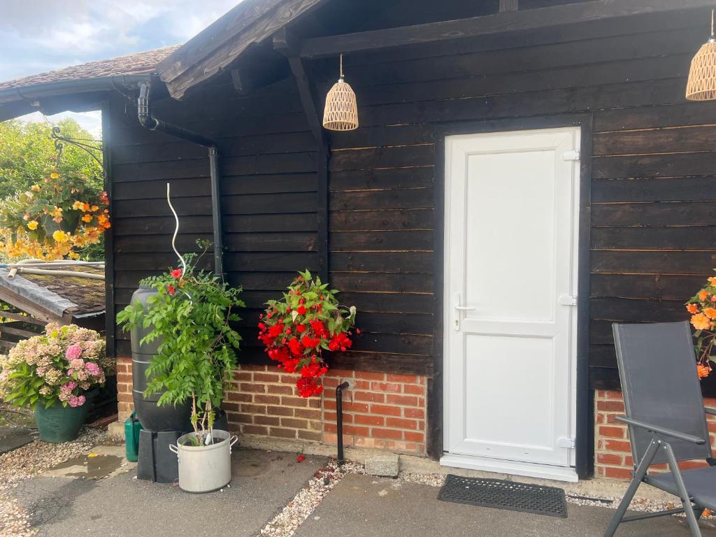 a house with flowers and a white door at The Little Red lion in Thorpe